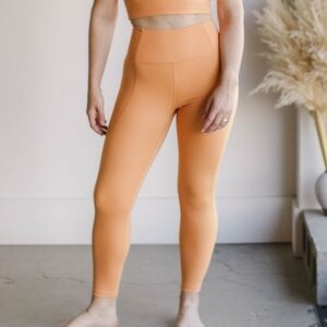 Girlfriend collective high rise compression leggings in horizon orange